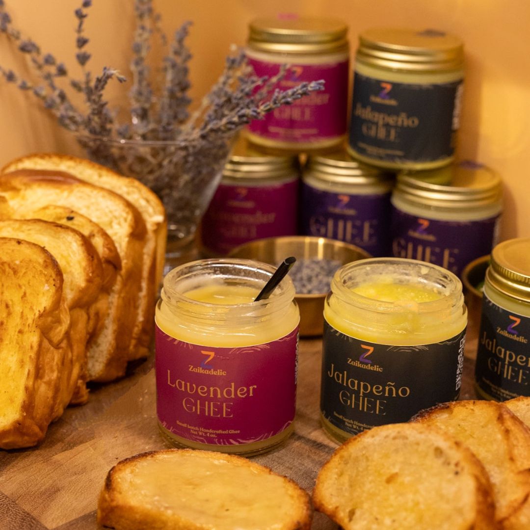 A bread board with various Zaikadelic ghee jars on it